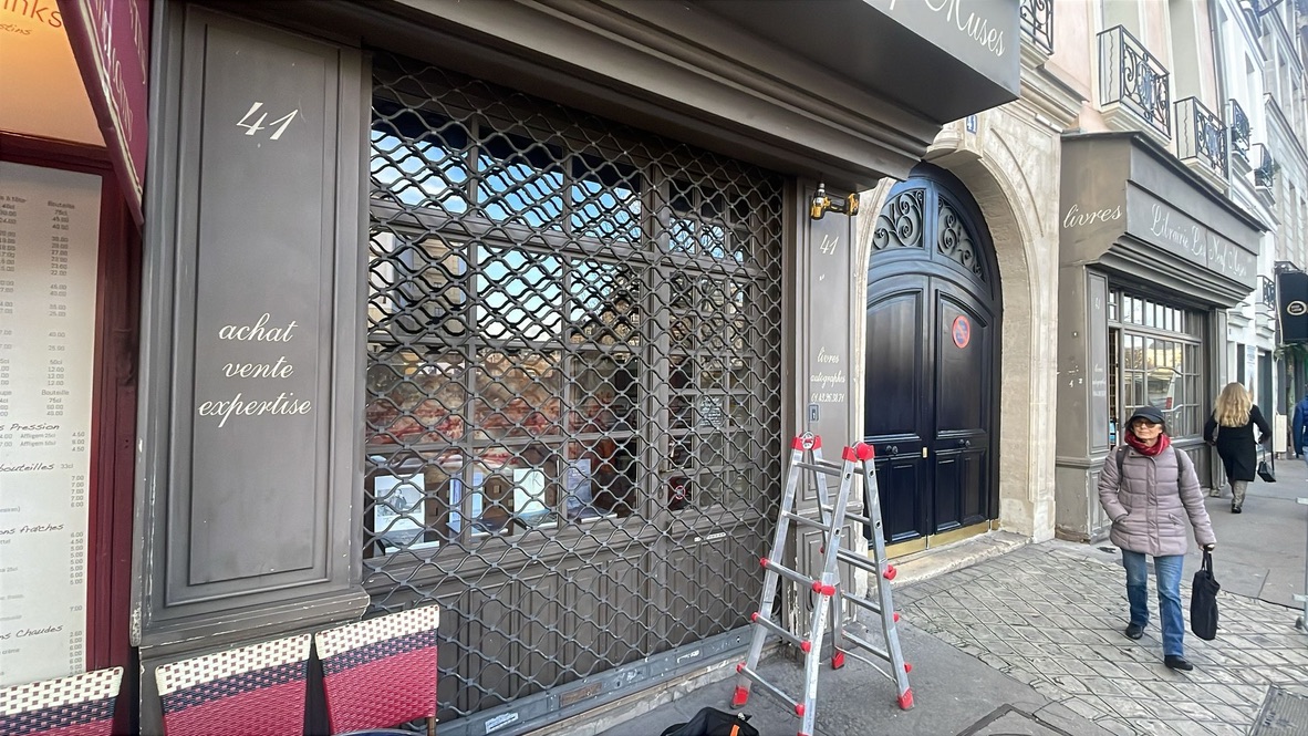 Grille métallique articulée fermée sur la vitrine d’un commerce